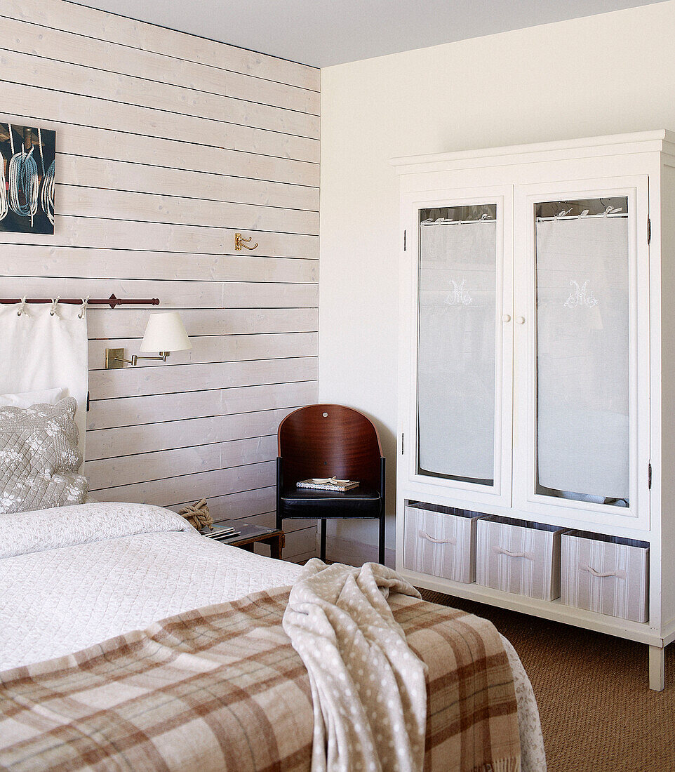 Karierte Decke auf einem Doppelbett mit Glasschrank in einem Gästehaus in der Bretagne, Frankreich