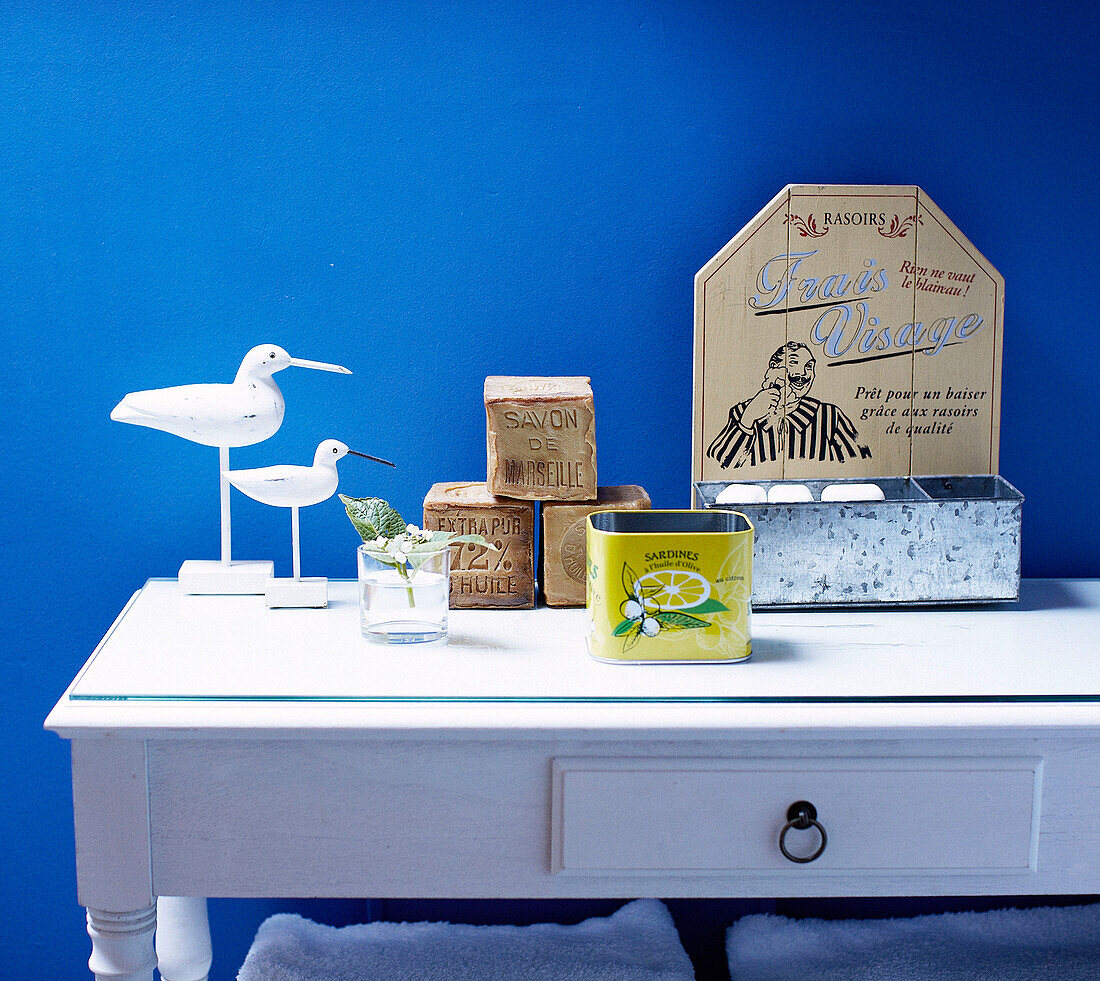 Möwenstatuen und Vorratsdosen mit Seife auf einem Beistelltisch in einem blauen bretonischen Gästehaus in Frankreich