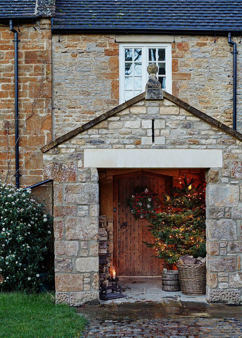 Beleuchteter Weihnachtsbaum in der Steinveranda eines Hauses in Oxfordshire England UK