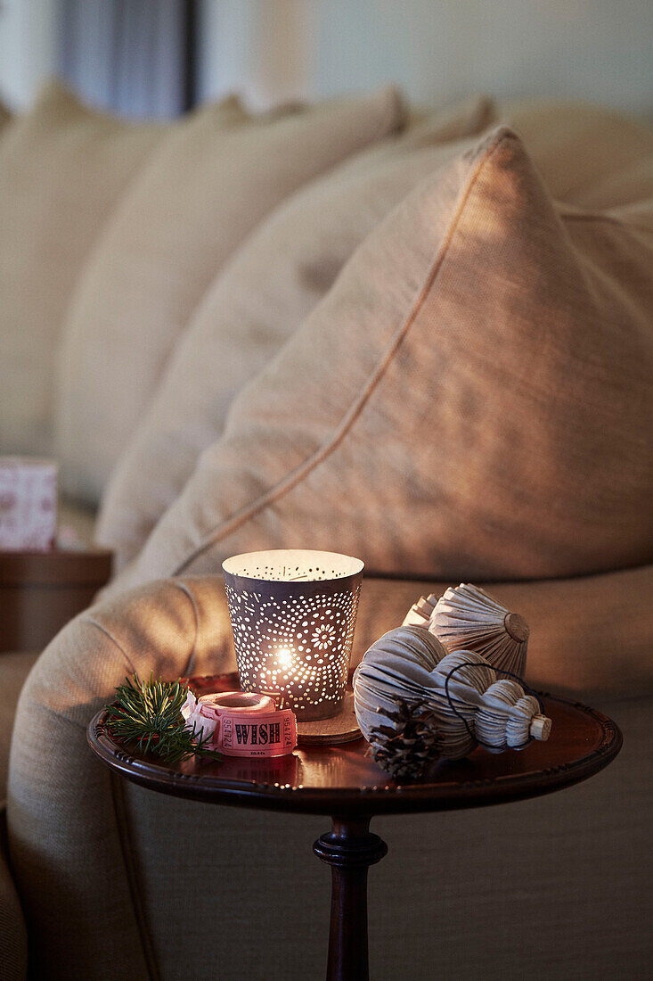 Beleuchtetes Teelicht und Weihnachtsdekoration mit Wunschband im Wohnzimmer in Oxfordshire, England, Vereinigtes Königreich