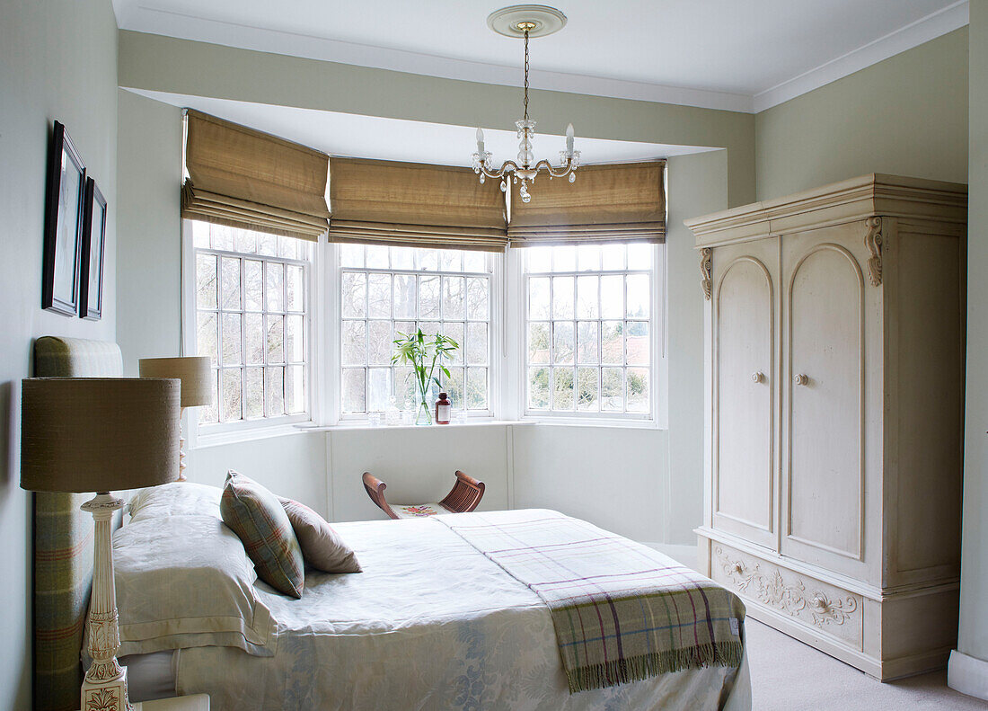 Roman blinds in bay window of double bedroom with wardrobe County Durham home England UK