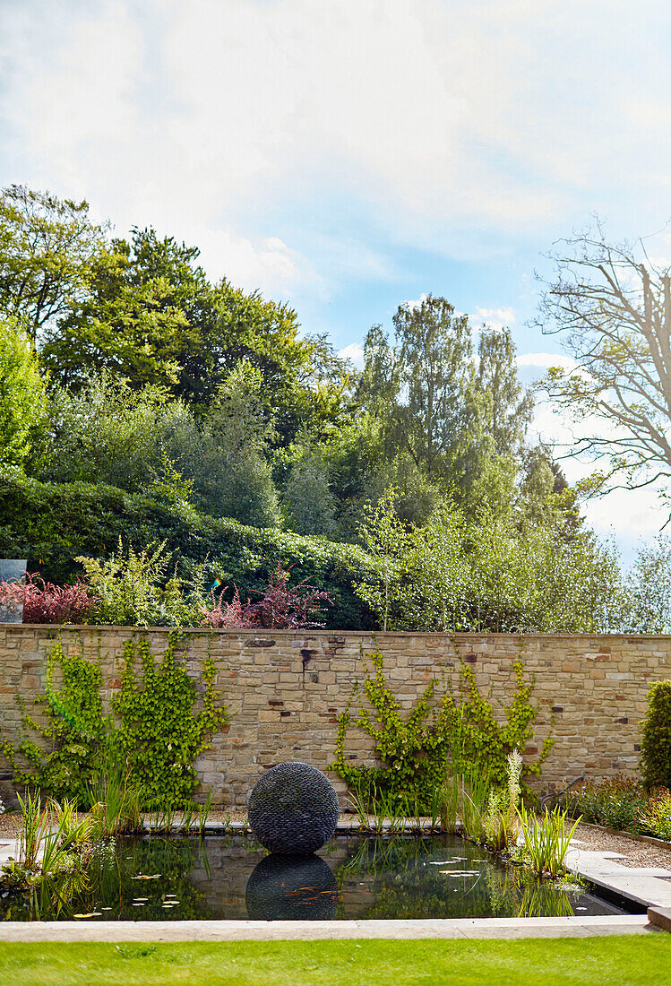 Gartenornament im Teich eines freistehenden Steinhauses aus dem 19. Jahrhundert in Northumberland, UK