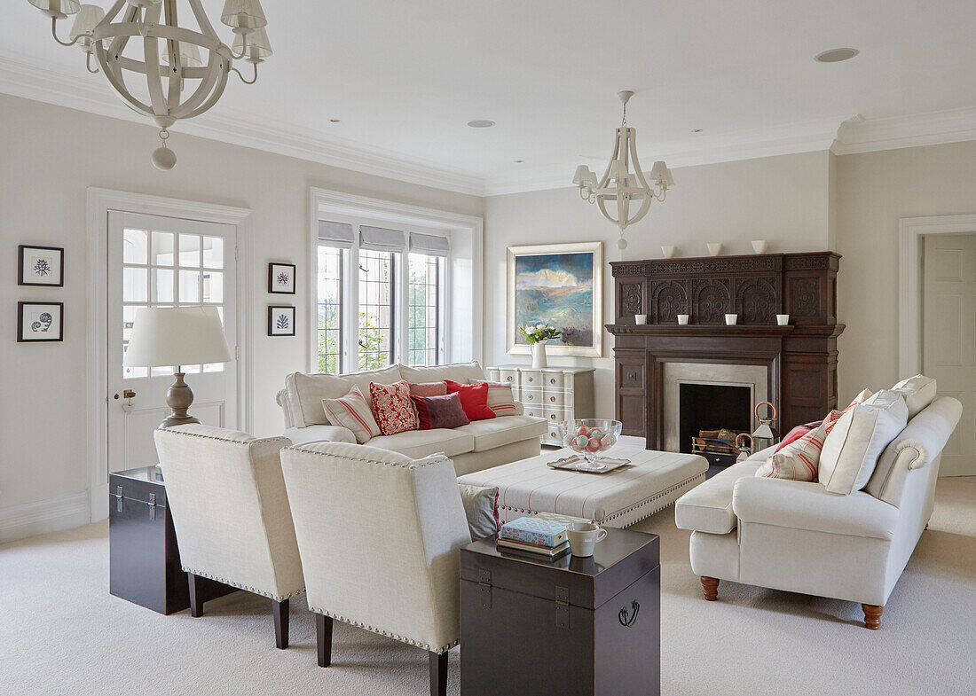Wooden chests and fireplace with white upholstered seating in Northumbrian country house UK