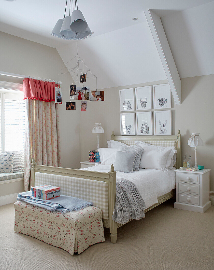 Familienfotos hängen über einem Einzelbett mit Deckenkasten im Schlafzimmer eines Mädchens in einem Landhaus in Northumbria, Großbritannien