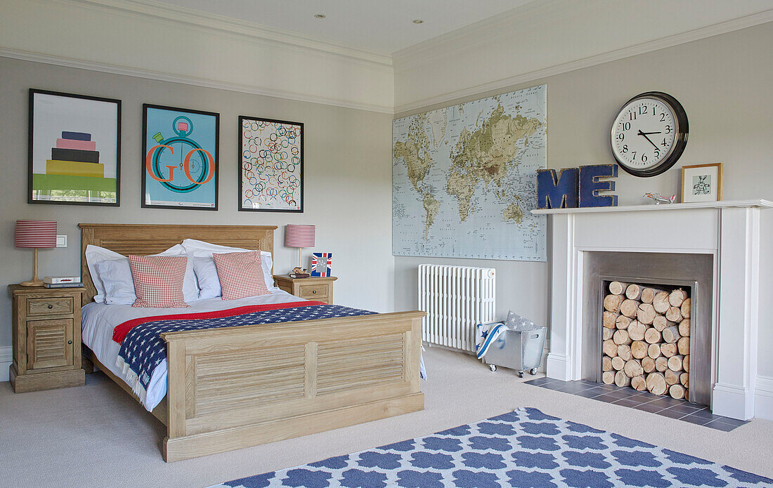 Moderne Kunst und Wandkarte im Schlafzimmer mit Kamin und blauem Teppich in einem Landhaus in Northumbria UK