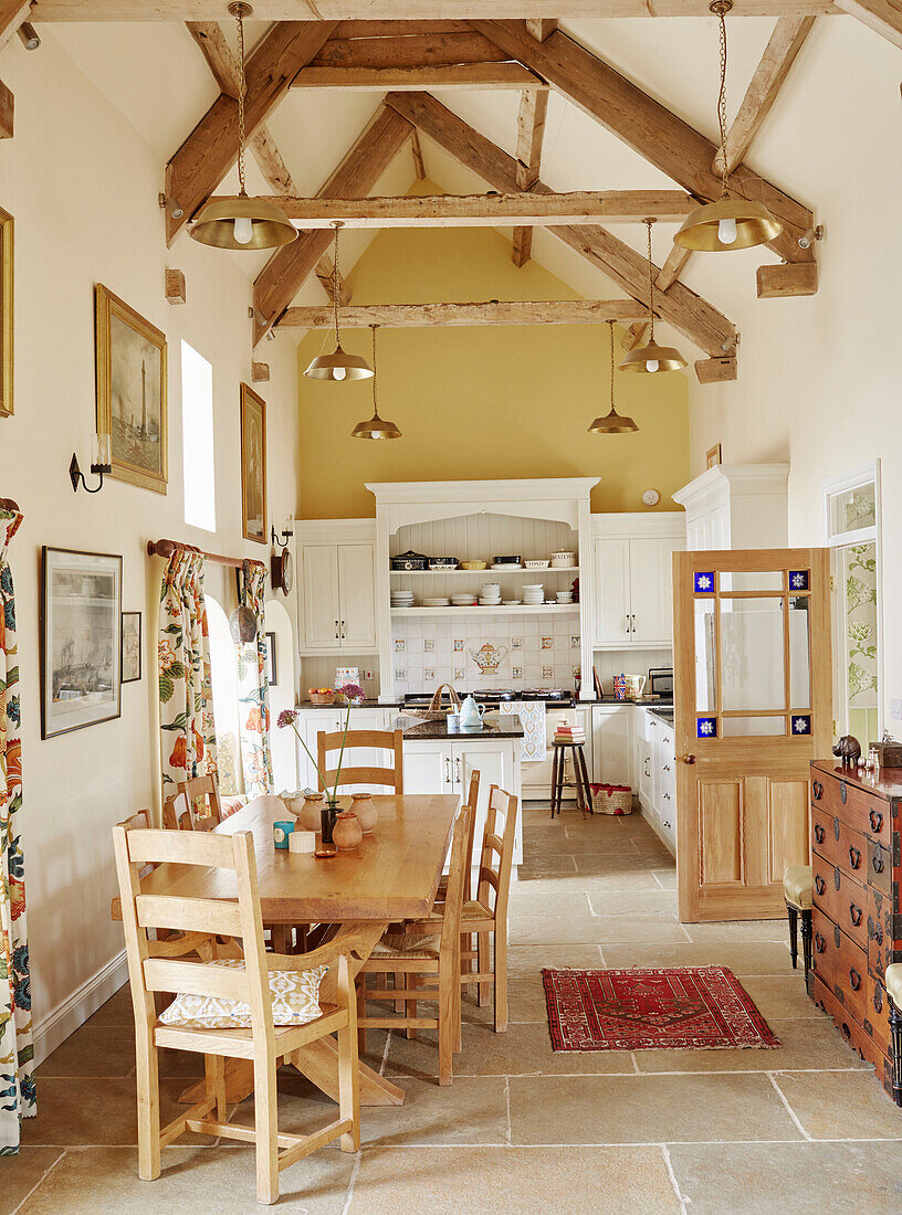 Wooden table and chairs in open plan beamed Hexham farmhouse kitchen Northumberland UK