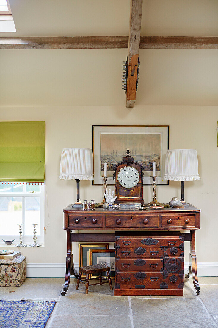 Antique clock on wooden sideboard with matching lamps in Hexham farmhouse Northumberland UK
