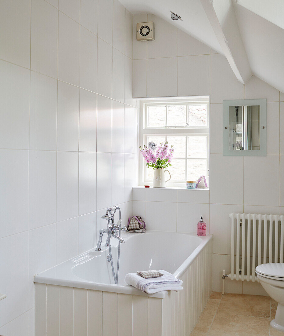 Weißes Badezimmer mit hellblauem Schrank in einem Haus in Northumbria, England, UK