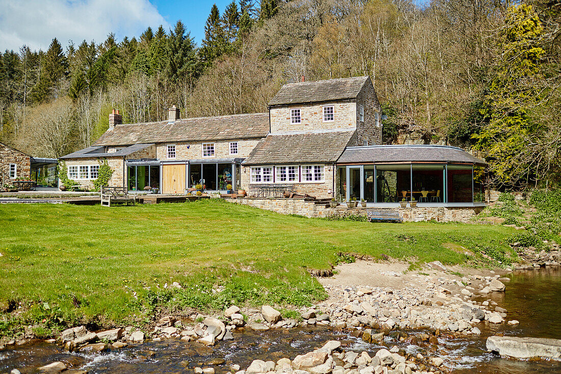 Renoviertes Mühlenhaus aus dem 18. Jahrhundert in einem Waldgebiet in Northumbria, UK