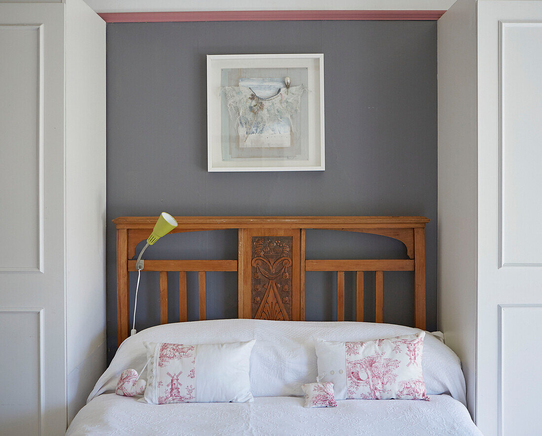 Framed artwork above carved wooden bed in Country Durham home, North East England