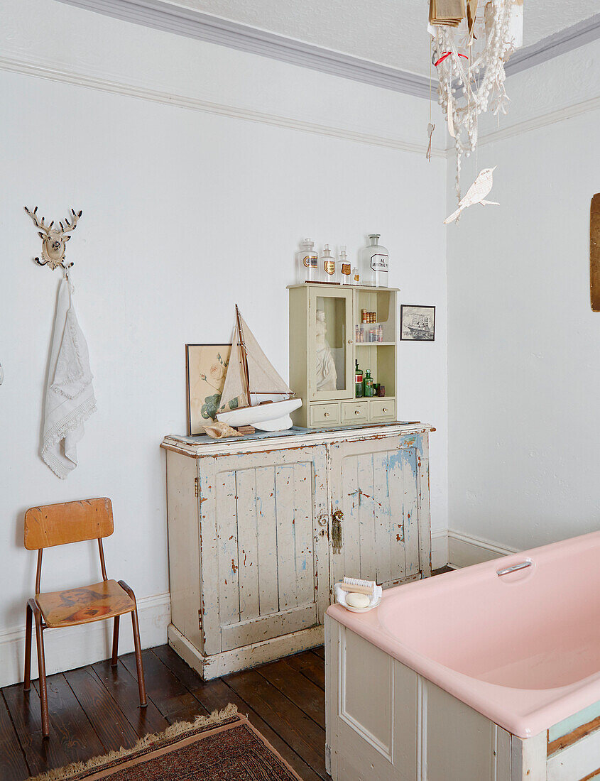 Chair and sideboard with pink bath in Country Durham home, North East England