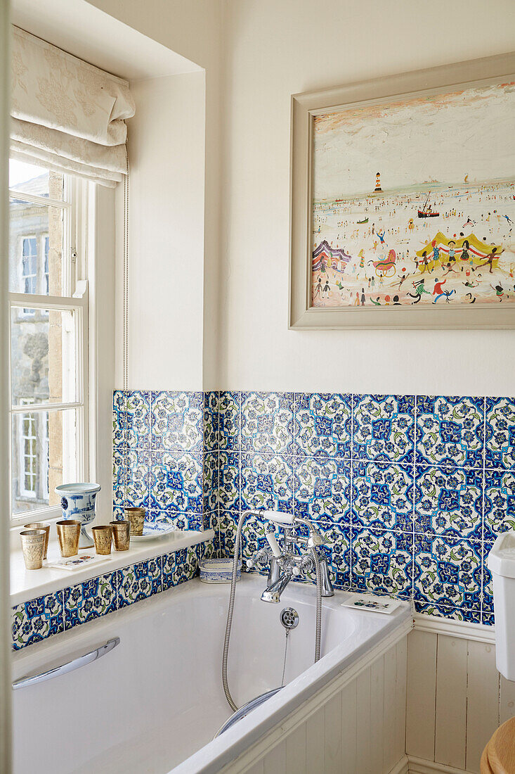 Blues tiled bathroom with framed artwork in Capheaton Hall, Northumberland, UK