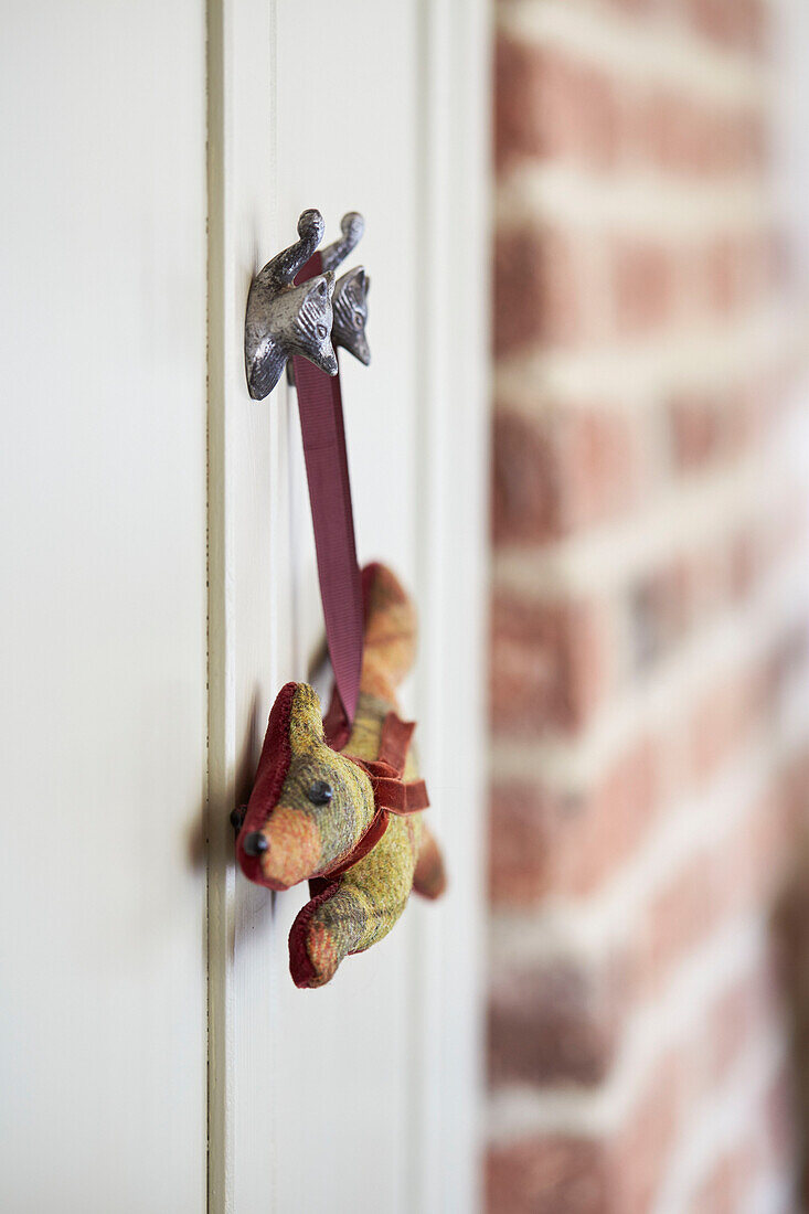 Handmade soft toy hanging from hook in Grade II listed Tudor bastle Northumberland UK