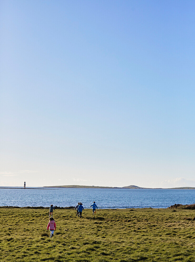 Kinder laufen zum Meer in der Grafschaft Sligo, in Connacht, Irland
