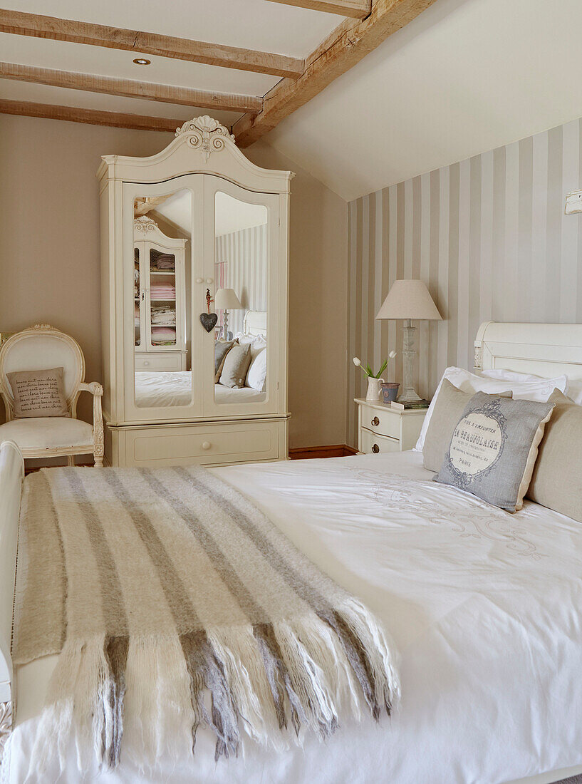 Gestreifte Decke auf Doppelbett und verspiegelter Kleiderschrank in einem Ferienhaus in der Grafschaft Durham, England, UK