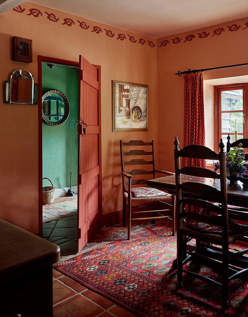 Orangetöne und Holzmöbel im Esszimmer eines Bauernhauses in Herefordshire, UK