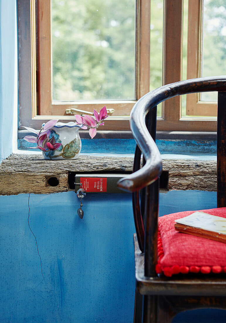 Schnittblumen im Krug auf der Fensterbank mit Stuhl in einem Bauernhaus in Herefordshire, UK