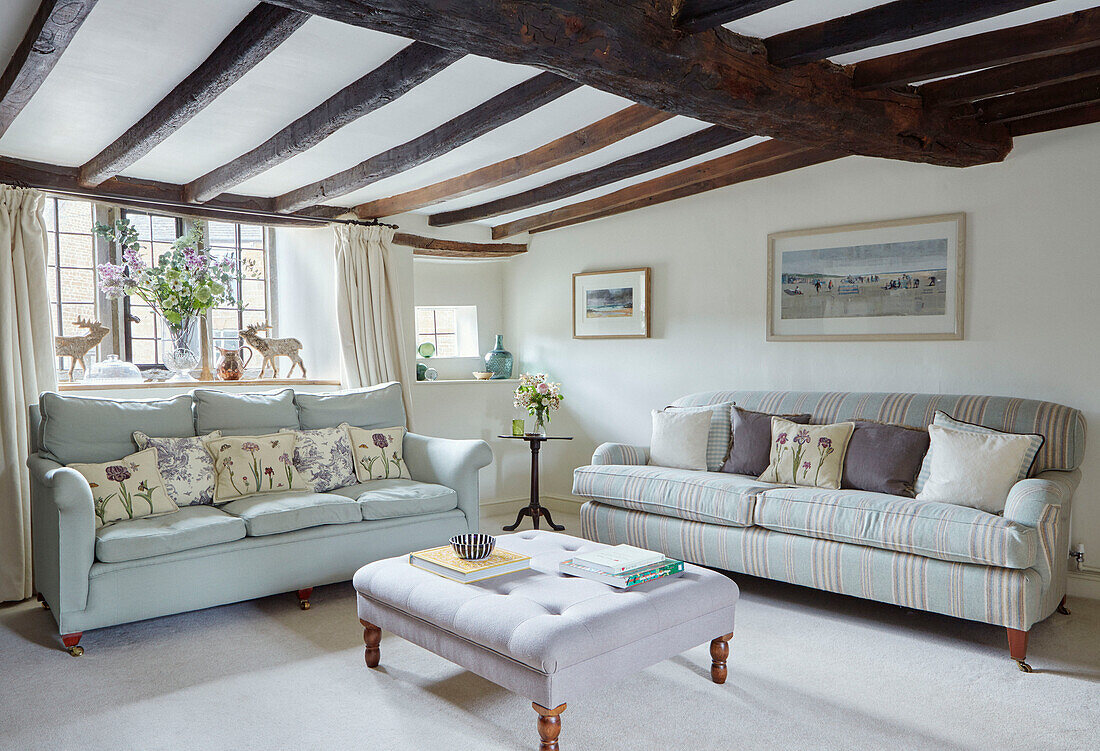 Hellgrüne Sofas mit geknöpfter Ottomane im Wohnzimmer von einem Cottage in Oxfordshire, UK