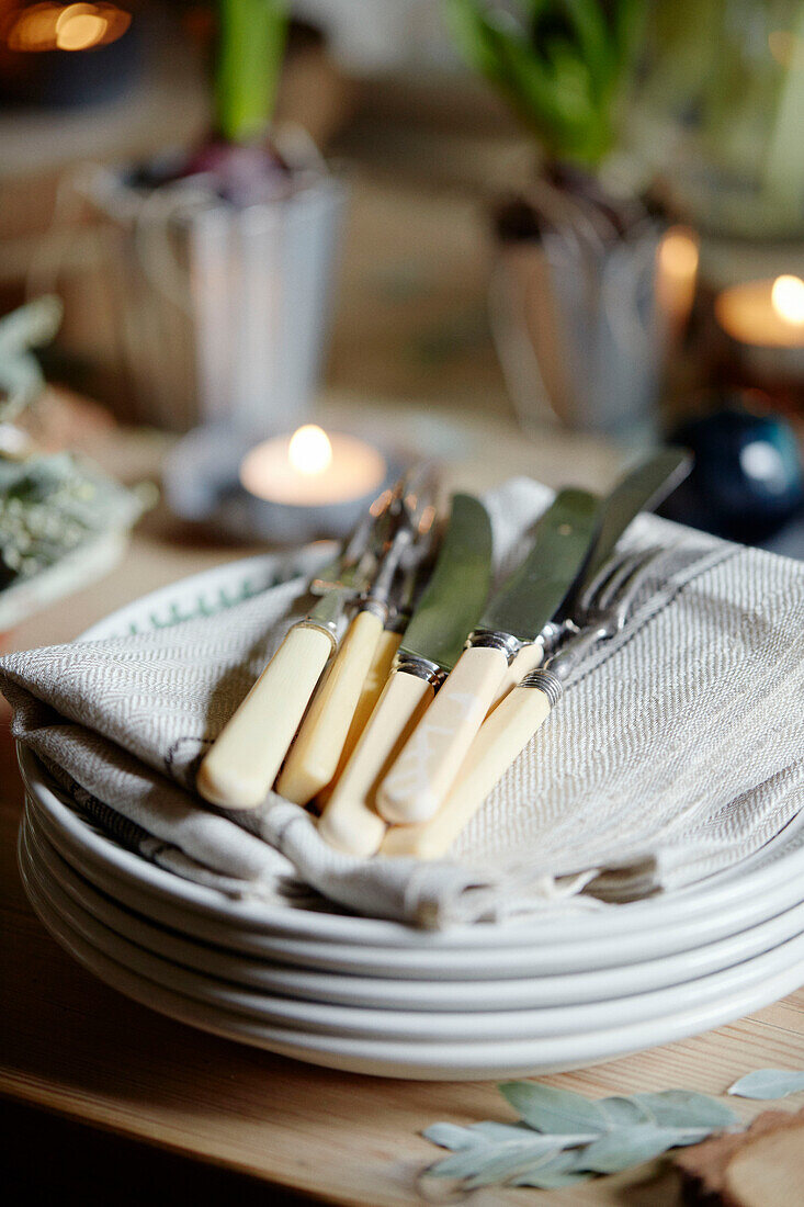 Messer und Gabeln auf Serviette mit Tellern in einem Haus in Chippenham, Wiltshire, UK