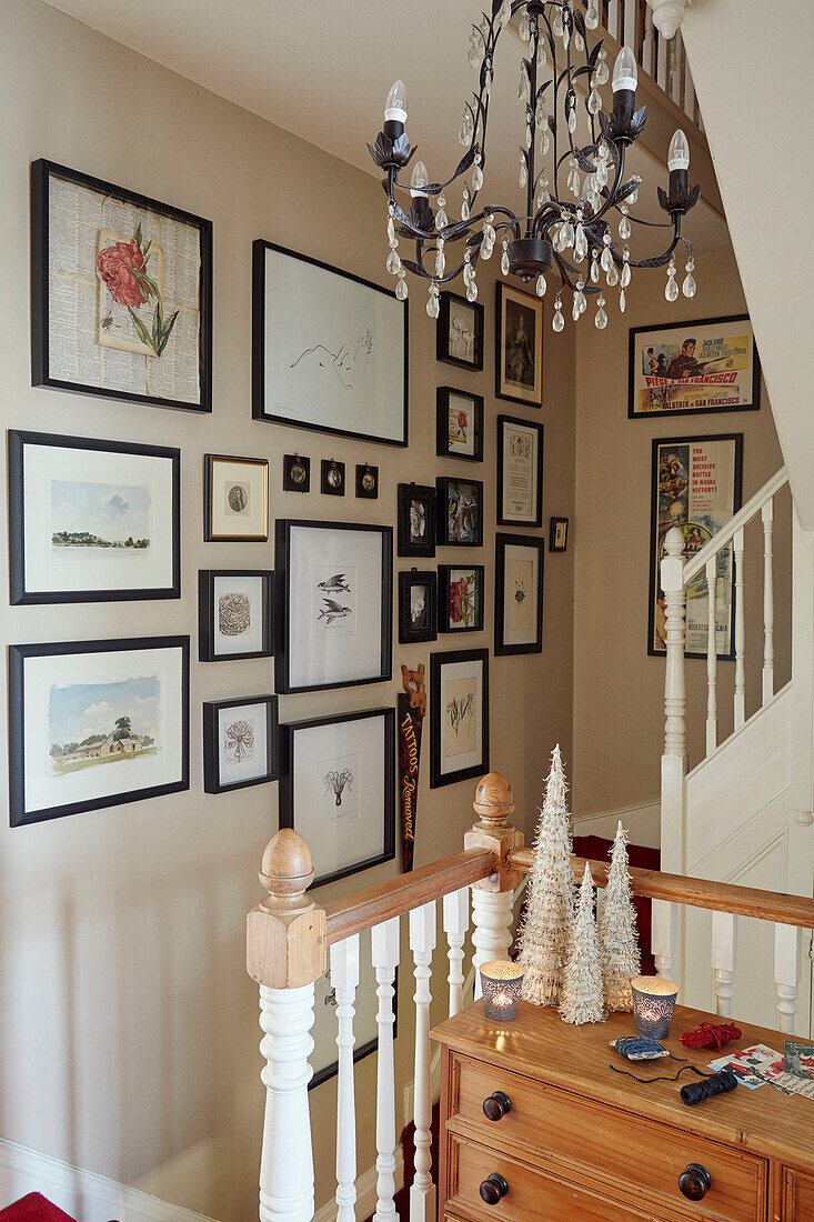Picture wall and chandelier in staircase of Chippenham home, Wiltshire, UK