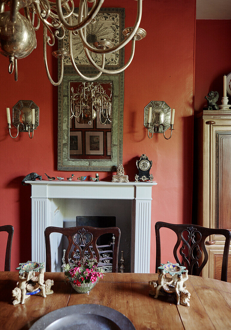 Holztisch und -stühle mit Ornamenten in einem roten georgianischen Esszimmer aus dem 19. Jahrhundert in Talgarth, Mid Wales, UK
