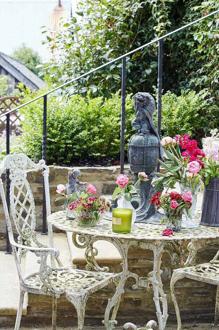 Weißer Eisenstuhl und Tisch auf der Gartenterrasse eines georgianischen Hauses in Talgarth, Mid Wales, UK