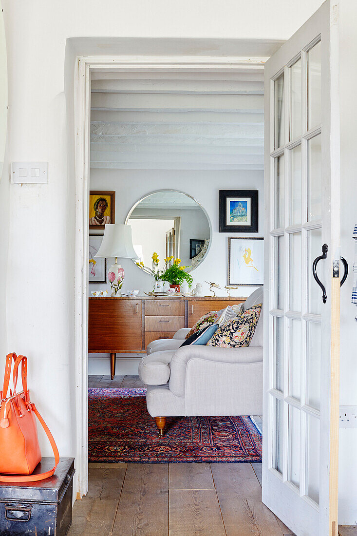 Orange handbag with view through doorway to vintage sideboard in living room of Yorkshire home, England, UK