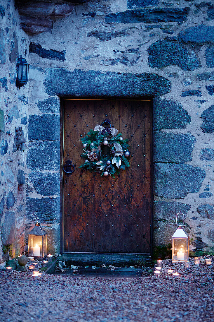 Lit lanterns at old wooden front door of Scottish castle, UK