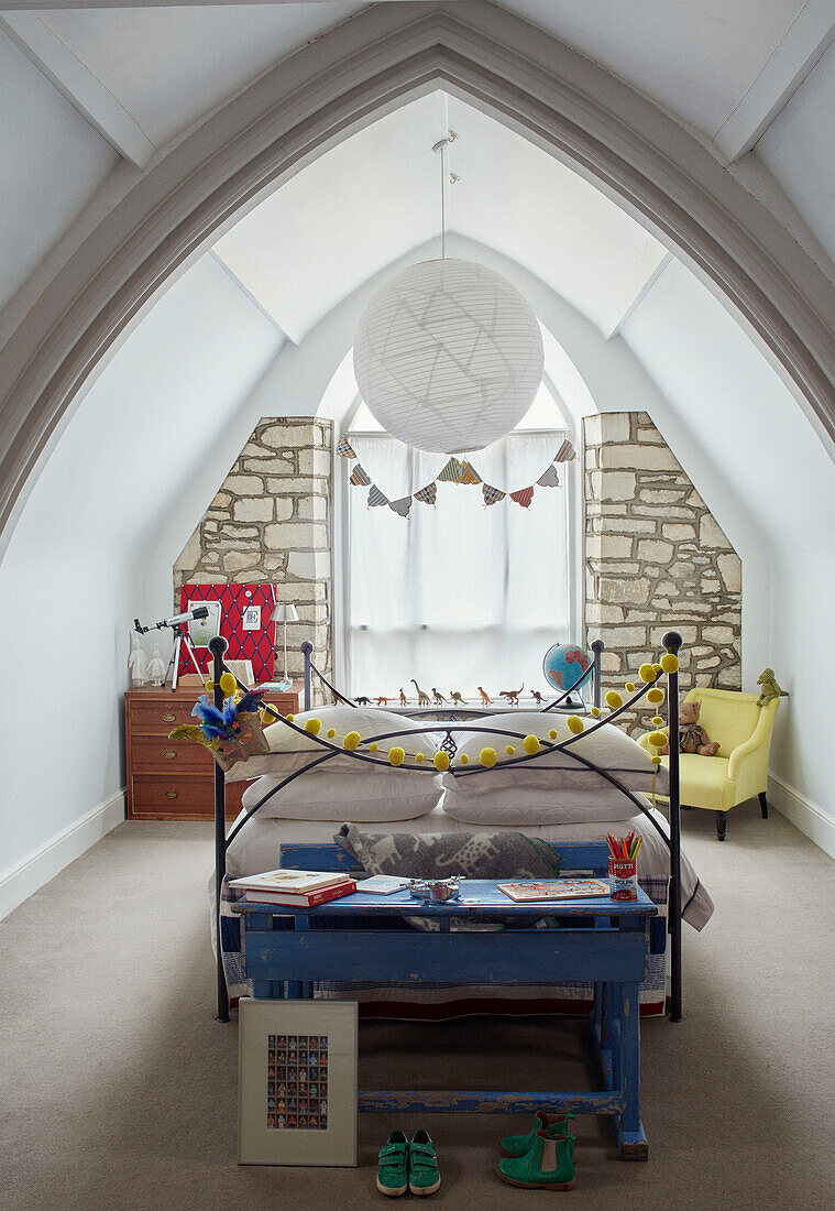 Große Pendelleuchte über dem Bett im Dachgeschoss der umgebauten Kirche in Woodstock, Oxfordshire, UK