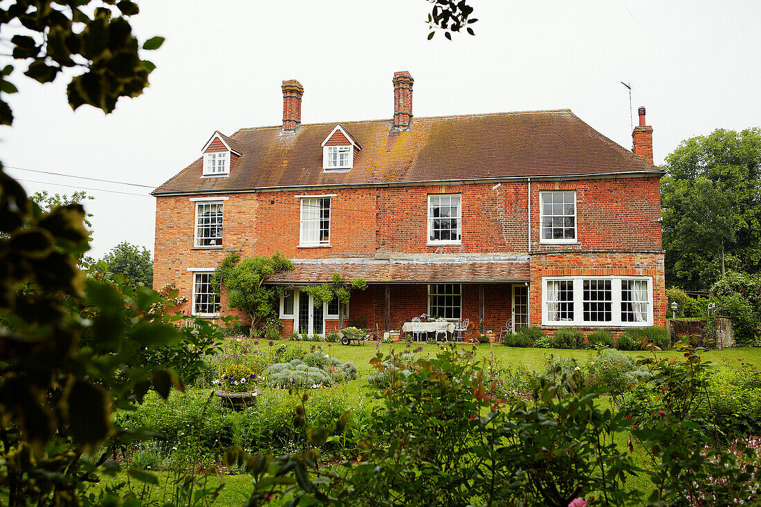 Garden exterior of detached brick Syresham home, Northamptonshire, UK