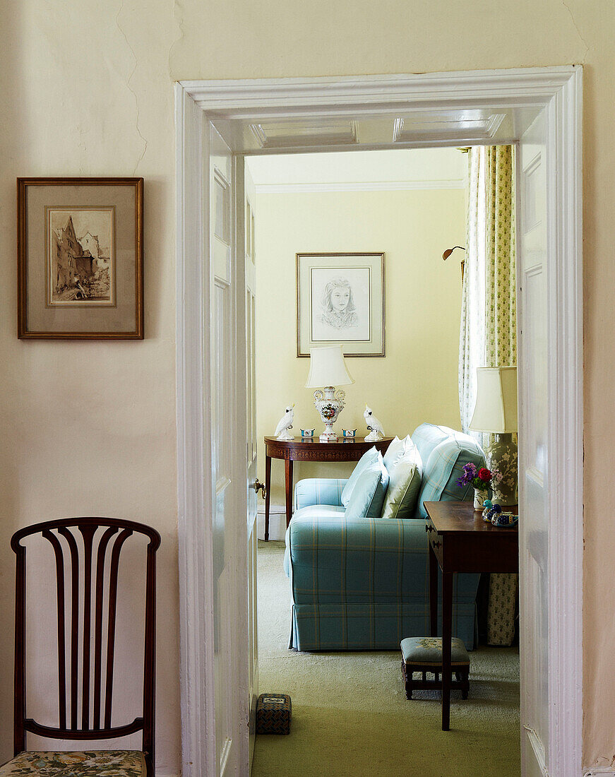 View through doorway to turquoise sofa in Syresham home, Northamptonshire, UK