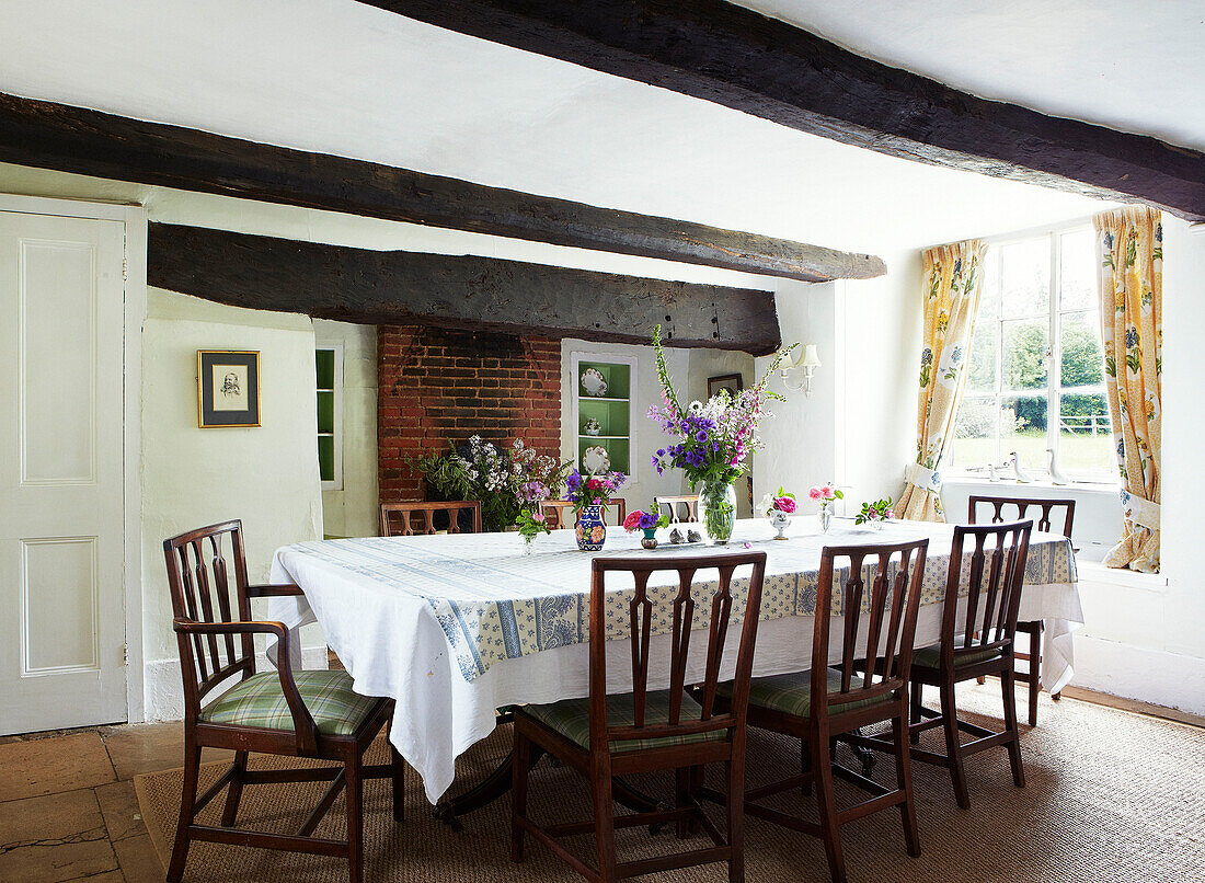 Wooden chairs at dining table in beamed Syresham home, Northamptonshire, UK