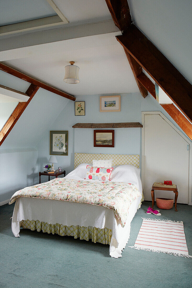 Hellblauer Dachbodenausbau mit gestepptem Bettbezug in einem Haus in Syresham, Northamptonshire, UK