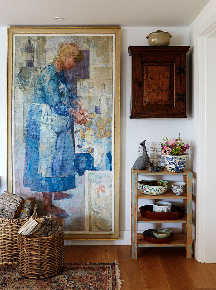 Large artwork and shelves with wall mounted cabinet in Oxfordshire farmhouse, UK