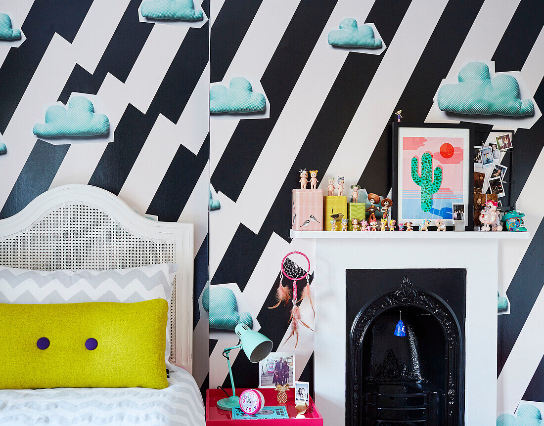 Forceful clouds wallpaper with toys on fireplace and single bed in South East London home, UK