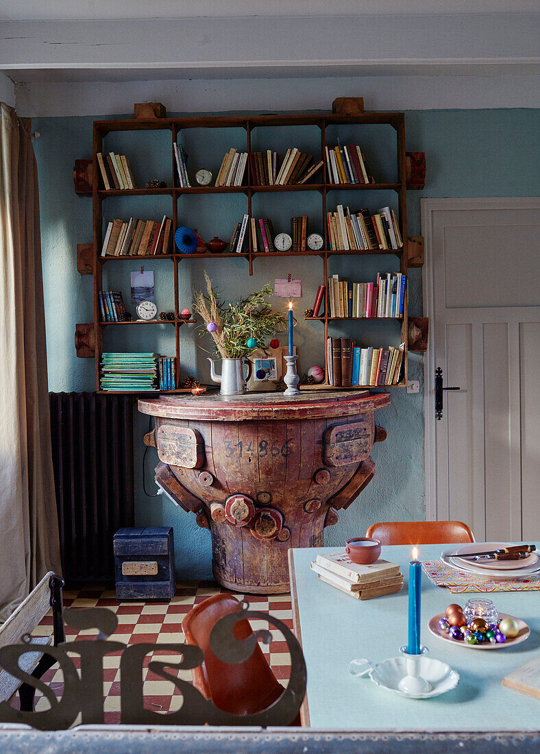 Secondhand-Holztisch mit wandmontiertem Bücherregal in einem bretonischen Landhaus in Frankreich