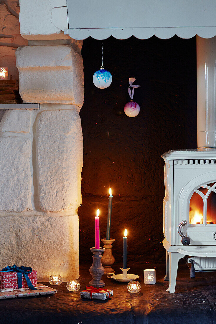 Angezündete Kerzen und Geschenke am Kamin in einem bretonischen Landhaus in Frankreich