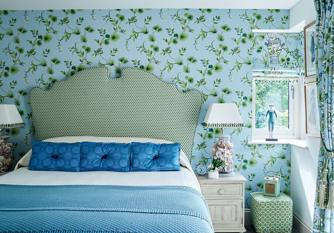 Grünes und blaues Schlafzimmer mit kontrastierenden Mustern und gepunktetem Kopfteil in einem Cottage in den Cotswolds, UK