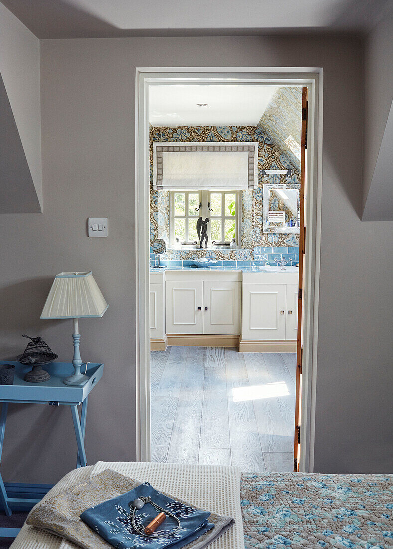 View through bedroom doorway to ensuite bathroom in Cotswolds cottage, UK