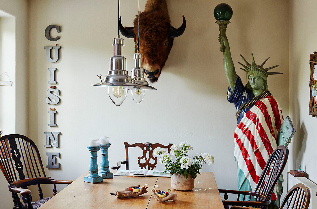 Wall mounted buffalo head and statue of liberty with letters spelling 'CUISINE' in Devon home, UK