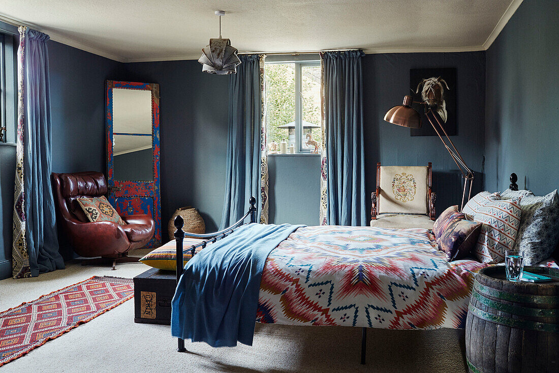 Hellblaues Schlafzimmer mit Vintage-Stuhl, Spiegel und Fass in einem Haus in Devon, UK