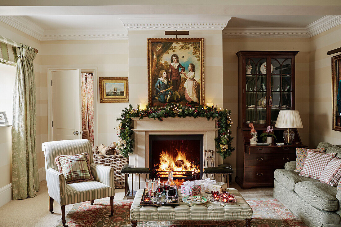 Picture above lit fire with Christmas garland in Cotswolds home, UK