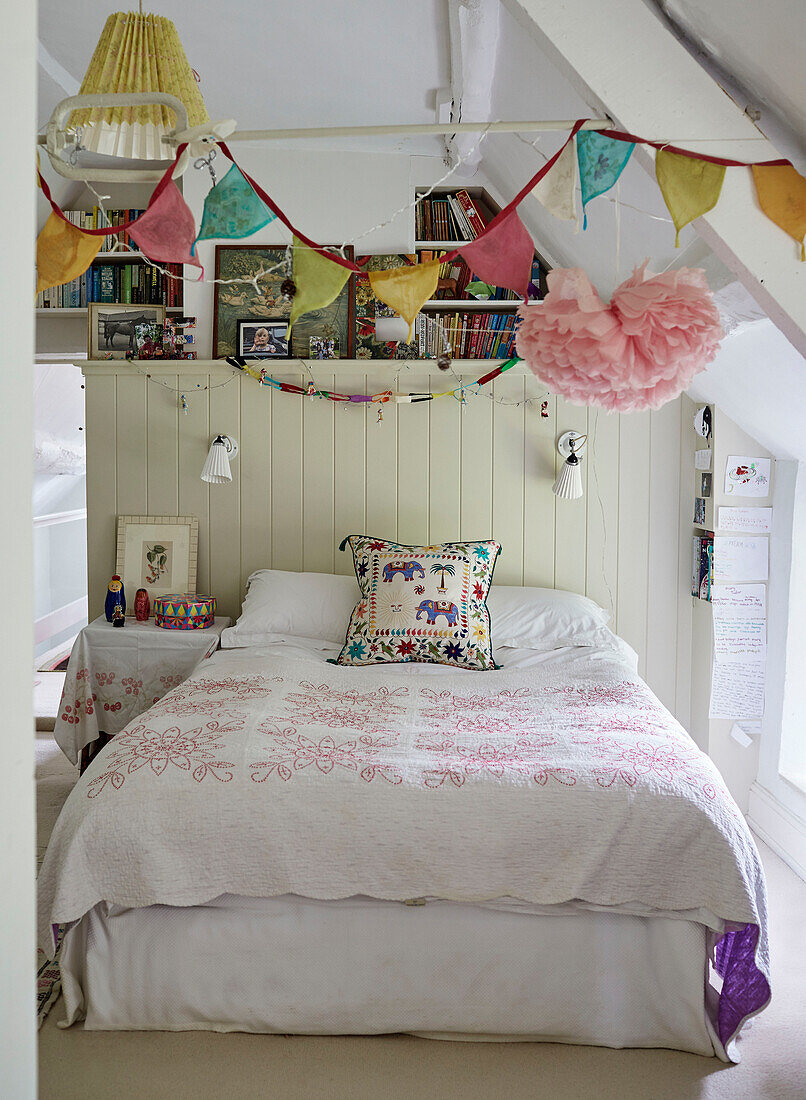 Bunting and books in girls room of Oxfordshire farmhouse, UK