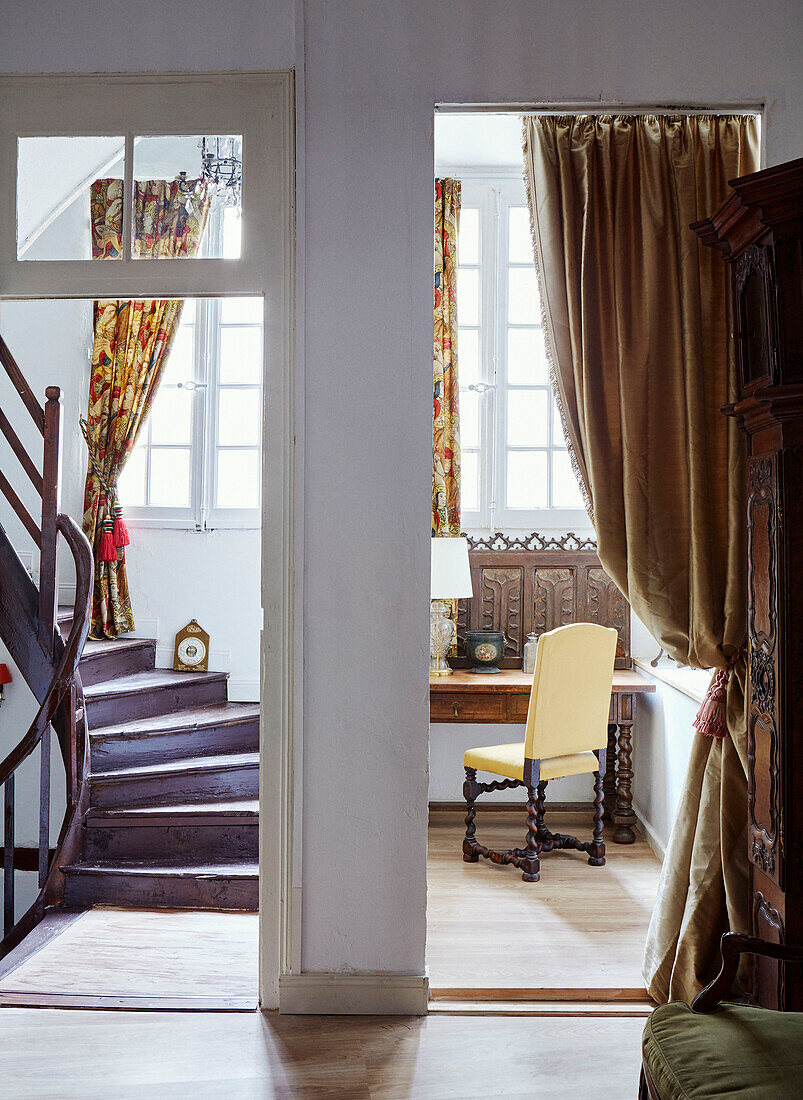 Yellow chair at desk with partitions wall and wooden staircase in Foix townhouse Ariege, France