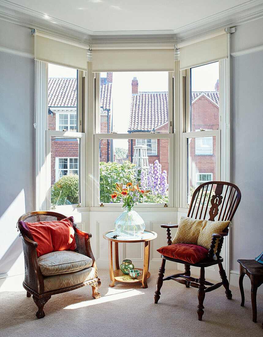 Nicht zusammenpassende Vintage-Stühle im Erkerfenster eines Hauses im Norden, UK