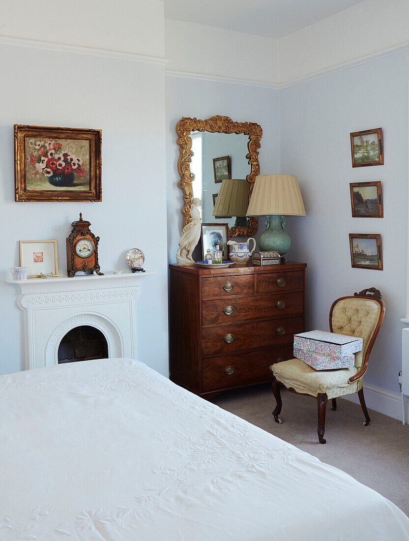 Cream lamp on wooden chest of drawers with framed prints in Northern home, UK