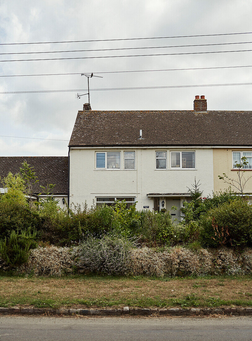 TV-Antenne und Vorgarten eines weißen Reihenhauses in Somerset, UK