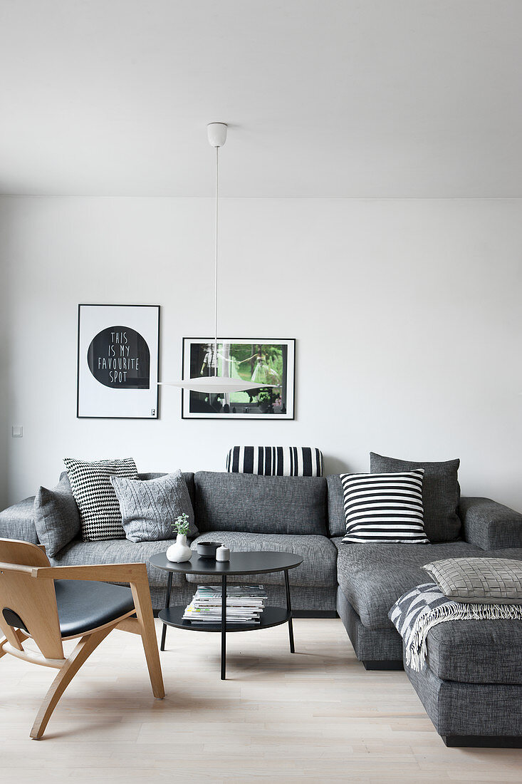 Grey sofa with black-and-white scatter cushions in simple living room