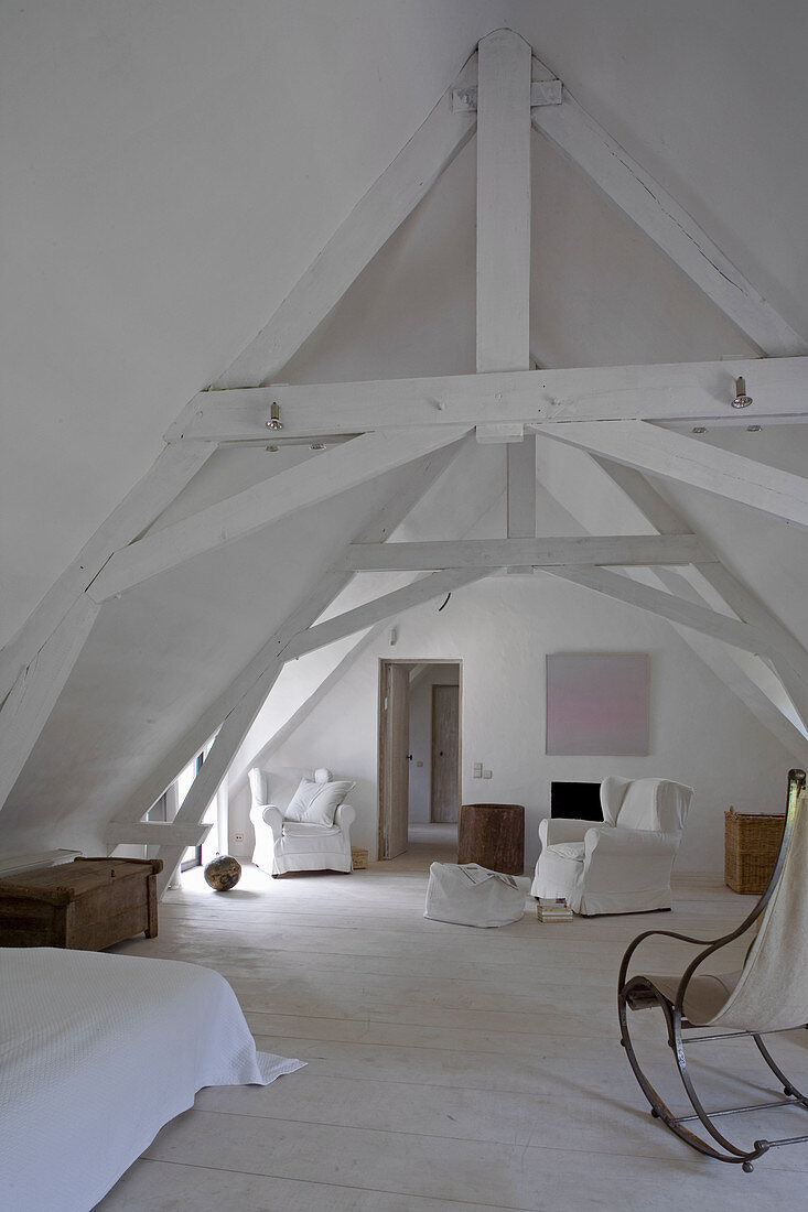Ländliches Dachzimmer in Weiß mit rustikalen Balken