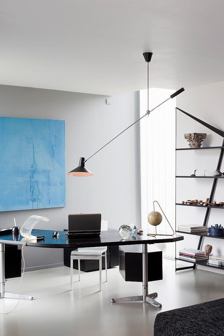 Cantilever ceiling lamp above desk in masculine interior